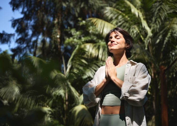 Happy,Calm,Young,Hispanic,Woman,Holding,Hands,In,Namaste,Meditating